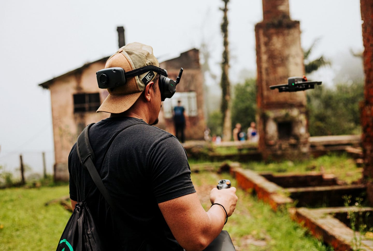 FPV pilot in goggles flying a custom quad during a test flight